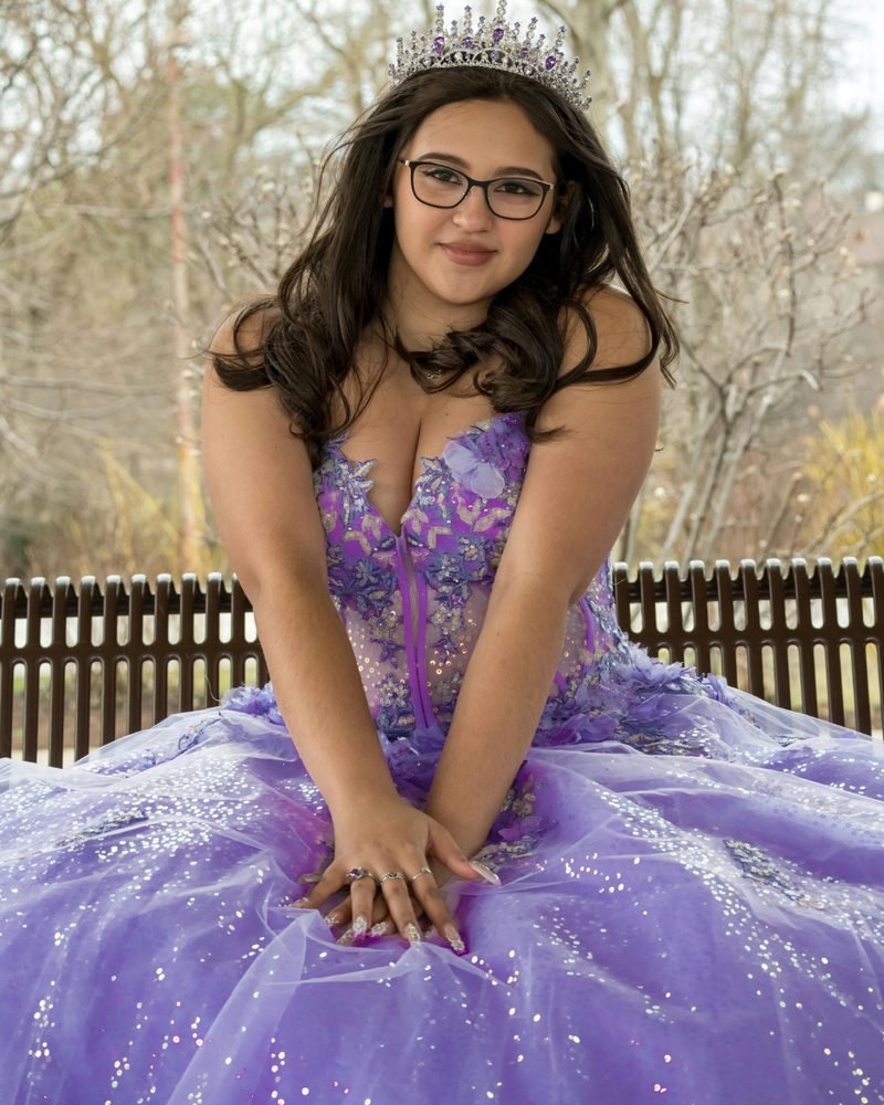 A young woman in a lilac gown with a tiara